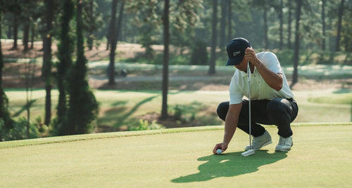 Golfer setting up a put